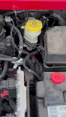 Brake fluid service work under a vehicle hood